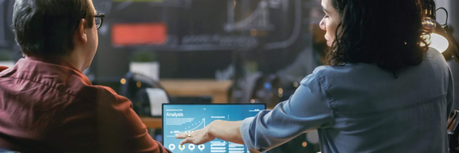 Man and woman looking at analytics on a laptop