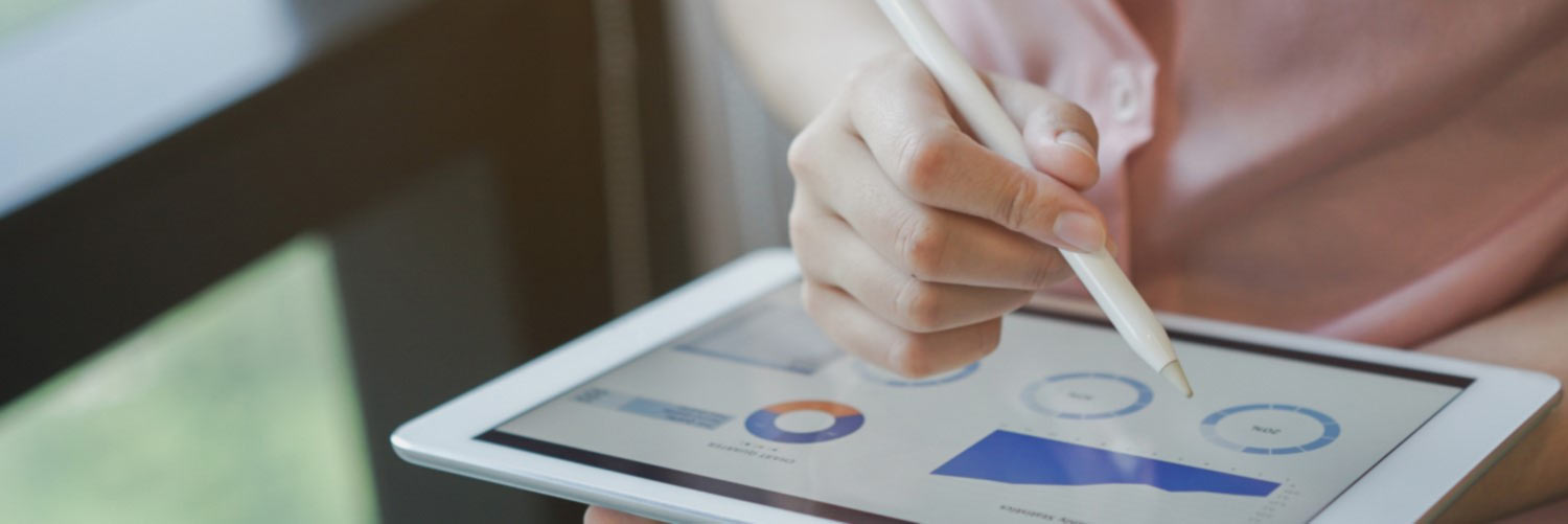 Woman looking at graphs and statistics on a tablet