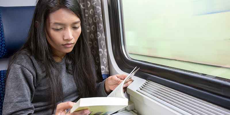 Student reading on a train