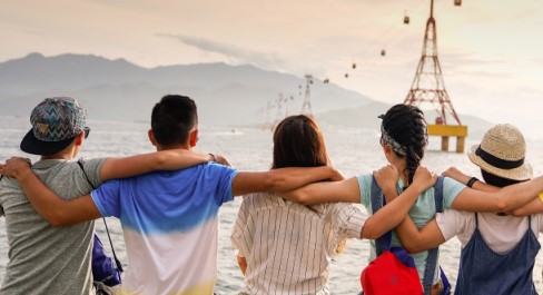 Group of friends arm-in-arm looking out to sea