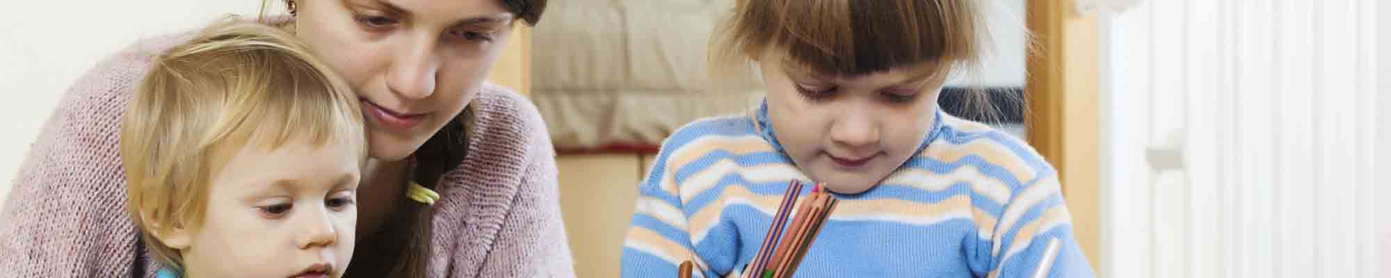 Serious mother and children sketching with pencils photo