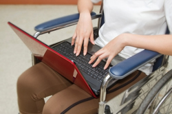person in wheelchair with laptop