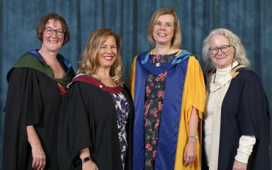 Jo Parker, Selena Killick, Cheryl Coveney, and Dr Jane Secker are all wearing graduation robes, standing next to each other and smiling at the camera.