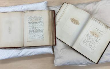 This image shows the volumes open to display letters from Charles Dickens and Florence Nightingale.