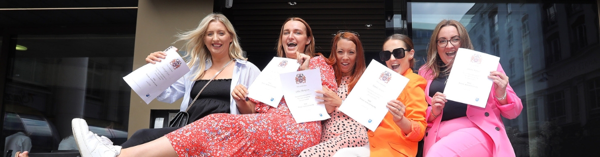 5 females celebrating holding certificates
