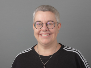 Photograph of a middle-aged white woman with short grey hair and spectacles
