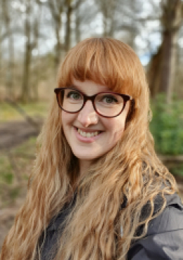 A picture of Dr Christine Plastow in a wooded area.