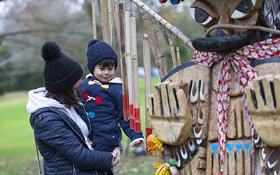 A woman and child view the Totem Latamat Indigenous artwork at The Crichton in Dumfries