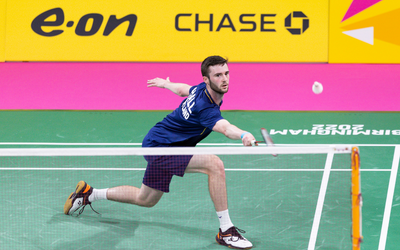 OU graduate and international badminton player Adam Hall pictured mid-game on a badminton court.