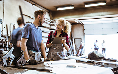 A man and woman in a metal workshop