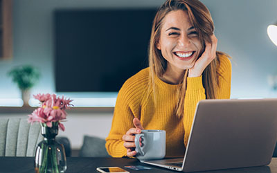 Smiling woman seated at laptop
