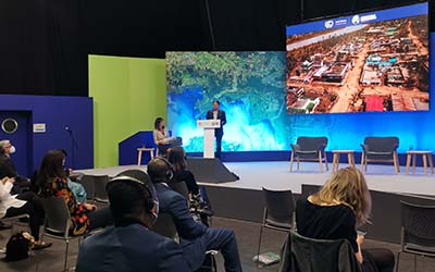 A delegate speaking on stage at COP26 in Glasgow