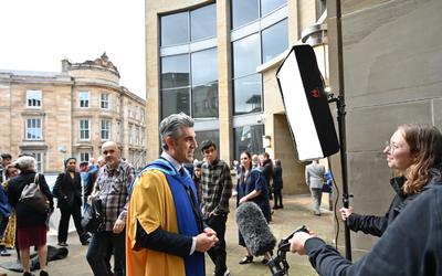 Open University honorary graduate Sabir Zazai being interviewed outside the Glasgow Royal Concert Hall.