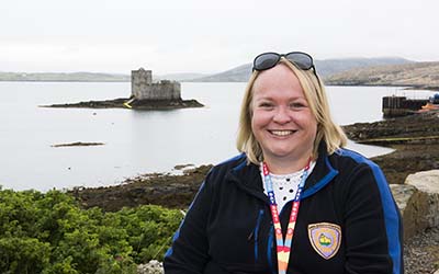 OU student Sarah at Castlebay, with the sea and castle in the background