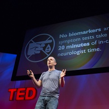 Max Little on stage, presenting a TED talk