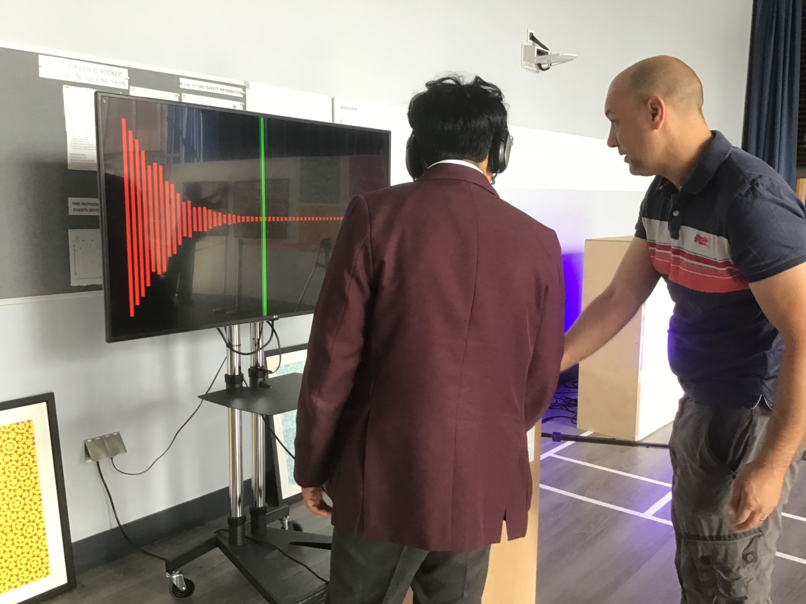 Two men watch a monitor with aperiodic tilings