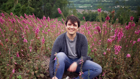 OU in Wales student Michael Rees sitting in a meadow