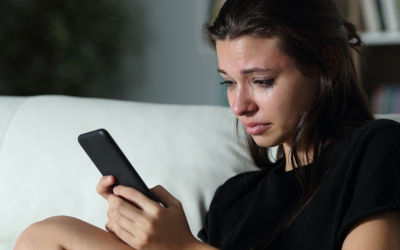 Woman crying holding a mobile phone